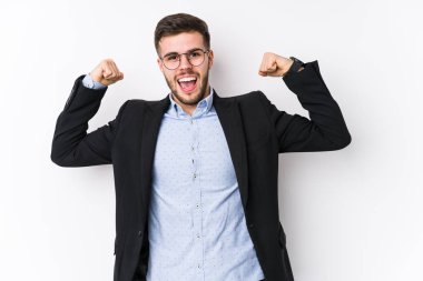 Beyaz arka planda poz veren beyaz tenli genç bir iş adamı, beyaz tenli genç beyaz bir iş adamının kollarıyla güçlü bir hareket göstermesi, kadınsı gücün sembolü.