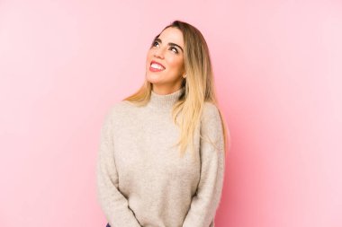Middle age woman over isolated background dreaming of achieving goals and purposes