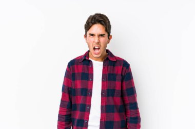 Pembe arka planda poz veren genç beyaz bir adam izole edilmiş çok kızgın ve agresif çığlıklar atıyor..