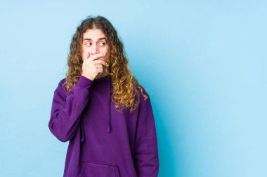 Uzun saçlı adam münzevi bir poz veriyor. Fotokopi odasına bakıyor. Ağzını eliyle kapatıyor..