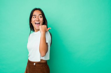 Genç melez Hintli kadın başparmak uzakta, gülerek ve kaygısız bir şekilde izole edilmiş..