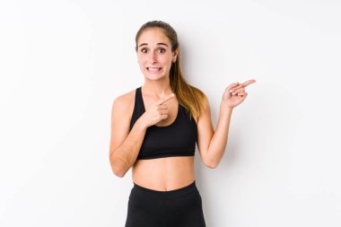 Beyaz arka planda poz veren beyaz tenli kadın işaret parmağıyla fotokopi alanını işaret ederek şok oldu..