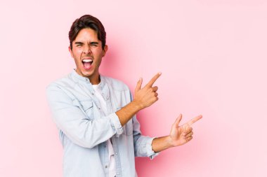 Pembe arka planda poz veren beyaz bir genç, işaret parmağıyla bir fotokopi alanını işaret ederek heyecan ve arzusunu ifade ediyor..
