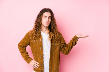 Genç, uzun saçlı bir adam avuçta fotokopi odası ve belinde bir el daha gösteriyor..