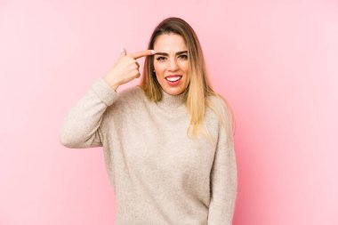 Middle age woman over isolated background showing a disappointment gesture with forefinger.