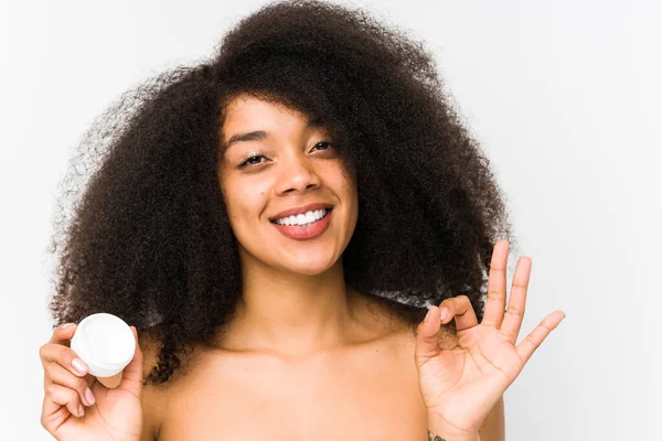年轻的非洲女人 拿着润肤霜 孤立地快乐而自信地做出了好的姿态 — 图库照片