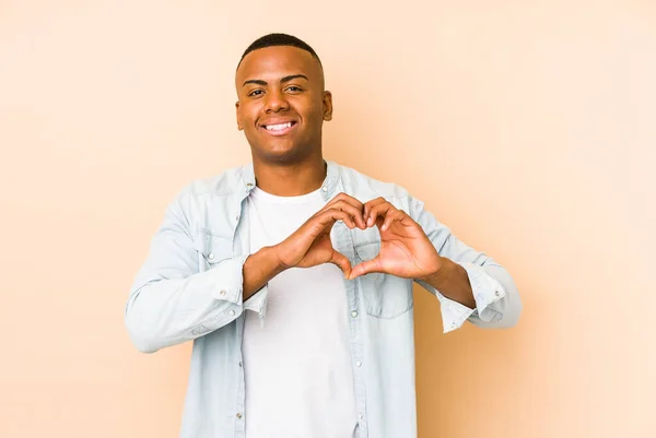 Young Latin Man Isolated Beige Background Smiling Showing Heart Shape — Stock fotografie