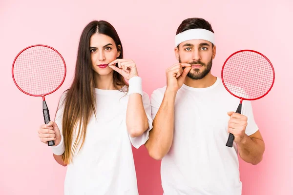 Casal Jovem Jogando Badminton Isolado Com Dedos Nos Lábios Mantendo — Fotografia de Stock