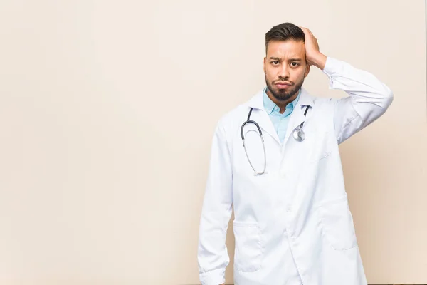 Young south-asian doctor man being shocked, she has remembered important meeting.