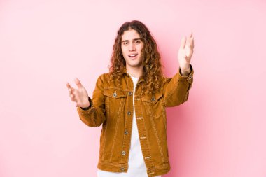 Yalnız poz veren uzun saçlı genç adam kameraya sarıldığı için kendinden emin görünüyor..