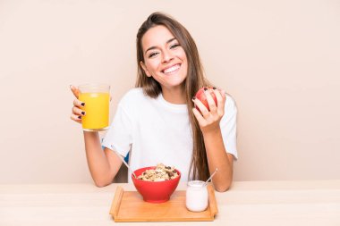 Genç beyaz kadın kahvaltı yapıyor.