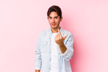 Pembe arka planda poz veren beyaz bir genç seni işaret ederek sanki seni davet ediyormuş gibi..