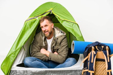 Senior inside a tent isolated on white background laughing and having fun.