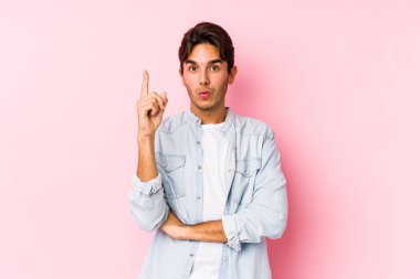 Pembe arka planda poz veren genç beyaz bir adam. Harika bir fikri var, yaratıcılık kavramı..