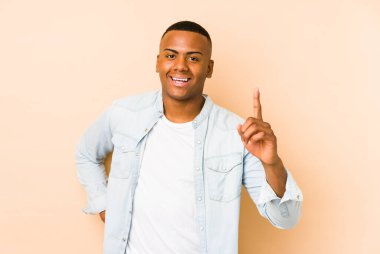 Young latin man isolated on beige background having an idea, inspiration concept.