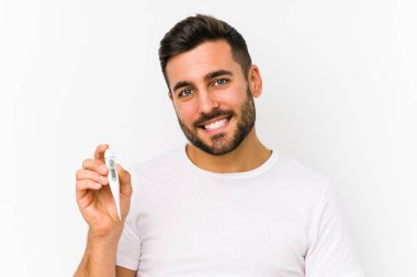 Elinde termometre tutan genç beyaz adam mutlu, gülümseyen ve neşeli bir beyaz adam tutuyor..