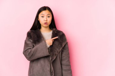 Yan tarafı gösteren, izole edilmiş bir ceket giyen genç Çinli kadın.