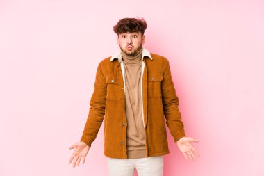 Pembe üzerinde yalnız poz veren genç bir Arap.