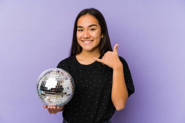 Genç Asyalı bir kadın bir balo düzenliyor. İzole edilmiş. Cep telefonu hareketini parmaklarıyla gösteriyor..