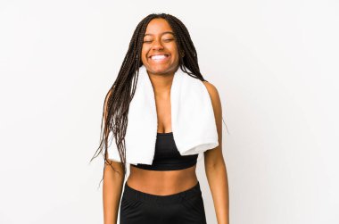 Genç Afro-Amerikan spor kadını yalnız gülüyor ve gözlerini kapatıyor, rahatlamış ve mutlu hissediyor..