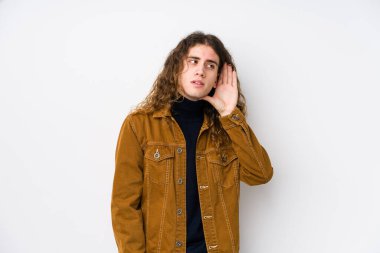 Uzun saçlı adam yalnız poz veriyor. Dedikoduları dinlemeye çalışıyor..