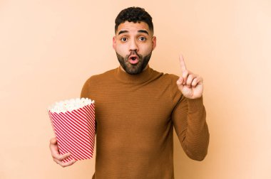 Elinde patlamış mısırla gezen genç latin adamın harika bir fikri var, yaratıcılık kavramı..