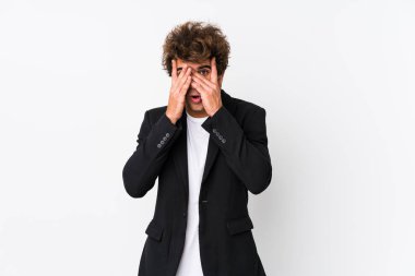 Beyaz arka planda beyaz tenli genç bir iş adamı korkmuş ve gergin parmaklarıyla göz kırp..