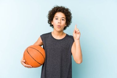 Basketbol oynayan çocuk mavi arka planda izole edilmiş. Harika bir fikri var. Yaratıcılık kavramı..