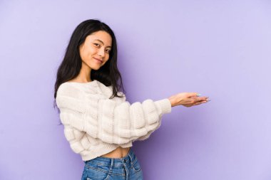 Mor bir arka planda izole edilmiş genç Çinli bir kadın. Elinde bir fotokopi odası var..