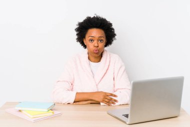 Orta yaşlı Afro-Amerikan kadın evde çalışıyor, yalnızlık çekiyor, yüzünde yorgun bir ifade var. Yüz ifadesi kavramı.