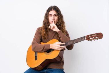Gitar çalan genç beyaz bir adam bir sır saklıyor ya da sessizlik istiyor..