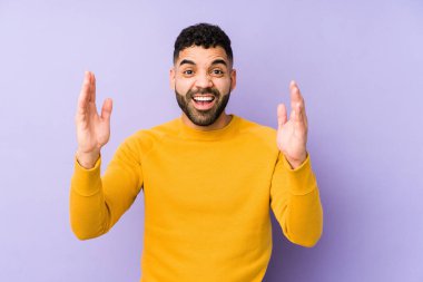 Genç, melez, Arap bir adam izole edilmiş. Hoş bir sürpriz bekliyor. Heyecanlı ve el kaldırıyor..