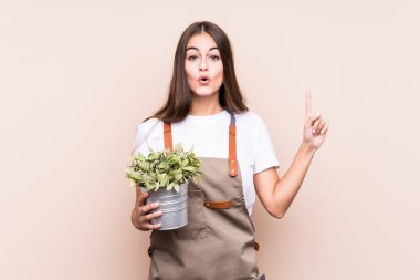 Genç bir bahçıvan elinde bir bitki tutan beyaz bir kadın büyük bir fikri, yaratıcılık kavramını benimsiyor..