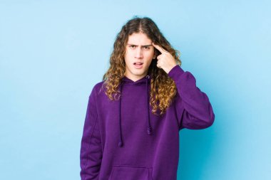 Uzun saçlı adam yalnız poz veriyor işaret parmağıyla hayal kırıklığı işareti yapıyor..