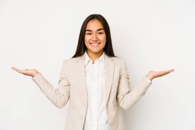 Beyaz bir arka planda izole edilmiş genç bir kadın kollarıyla ölçek oluşturuyor, mutlu ve kendinden emin hissediyor..