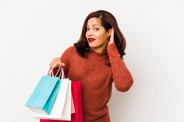 Medelålders Latinamerikansk Kvinna Håller Shoppingpåse Isolerad Försöker Lyssna Ett Skvaller — Stockfoto