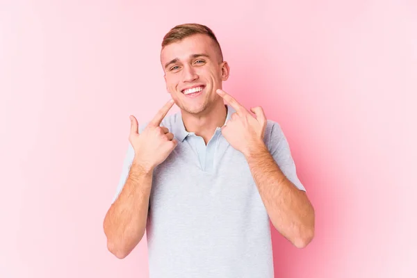 Jovem Caucasiano Isolado Sorri Apontando Dedos Para Boca — Fotografia de Stock
