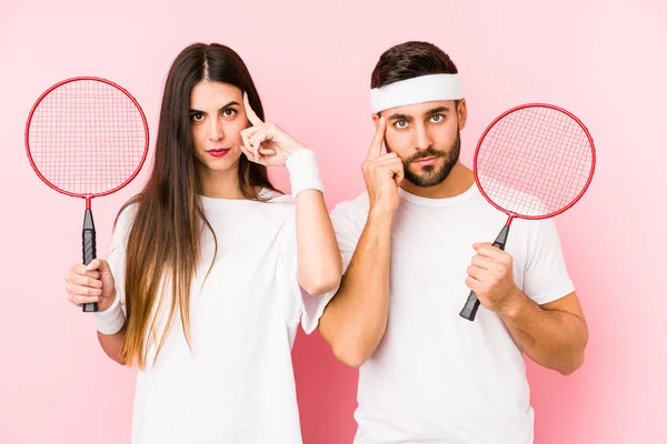 Casal Jovem Jogando Badminton Isolado Apontando Templo Com Dedo Pensando — Fotografia de Stock