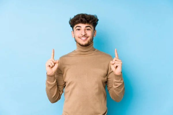 Hombre Árabe Joven Aislado Indica Con Ambos Dedos Delanteros Hacia —  Fotos de Stock