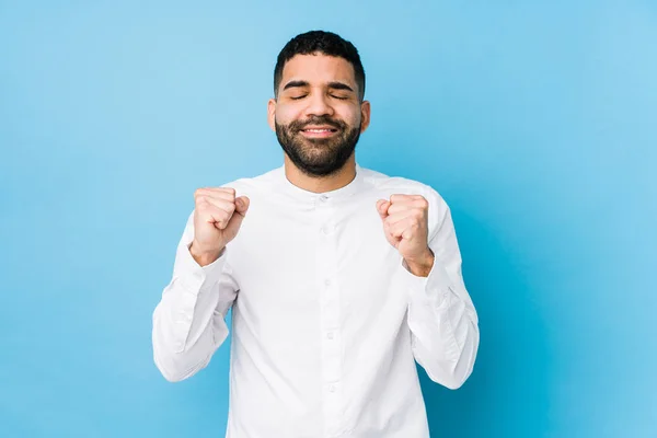 Mladý Latinský Muž Modrém Pozadí Izolovaný Zvedající Pěst Šťastný Úspěšný — Stock fotografie