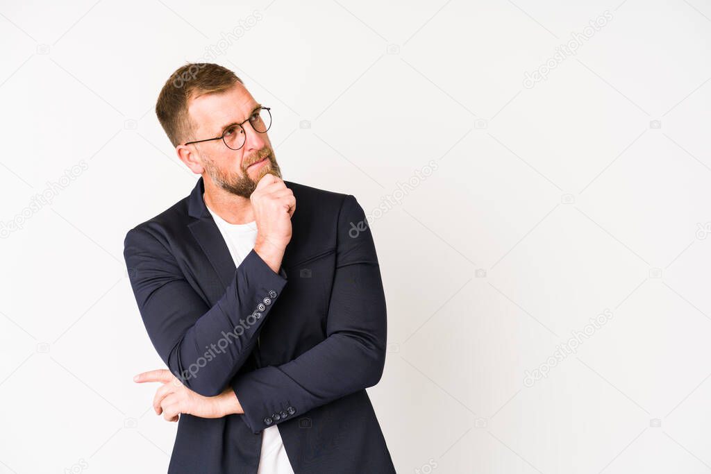 Senior business man isolated on white background looking sideways with doubtful and skeptical expression.