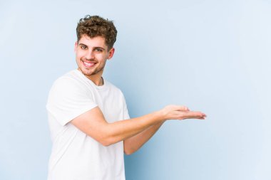 Sarışın, kıvırcık saçlı, beyaz tenli bir adam avucunun içinde bir kopya alanı tutuyor..