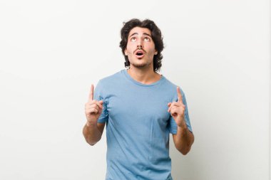 Beyaz arka planda ağzı açık genç ve yakışıklı bir adam..