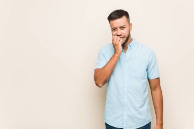 Tırnak yiyen genç Güney Asyalı adam, gergin ve çok endişeli..