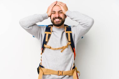Beyaz bir arka planda izole edilmiş genç bir sırt çantalı adam ellerini başının üstünde tutarak neşeyle gülüyor. Mutluluk kavramı.