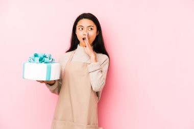 Elinde bir pasta tutan genç Çinli kadın tapınağı parmağıyla işaret ediyor, düşünüyor ve bir göreve odaklanıyor..