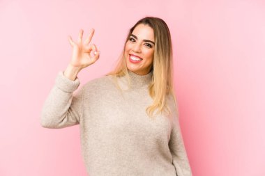 Middle age woman over isolated background cheerful and confident showing ok gesture.