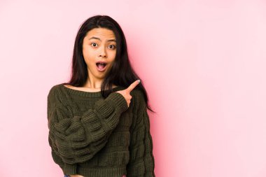 Pembe arka planda izole edilmiş genç Çinli kadın...