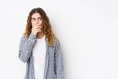 Genç, uzun saçlı adam münzevi bir poz veriyor. Fotokopi odasına bakıyor. Ağzını eliyle kapatıyor..