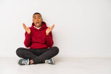 Yerde oturan genç latin adam şaşırdı ve şok oldu..